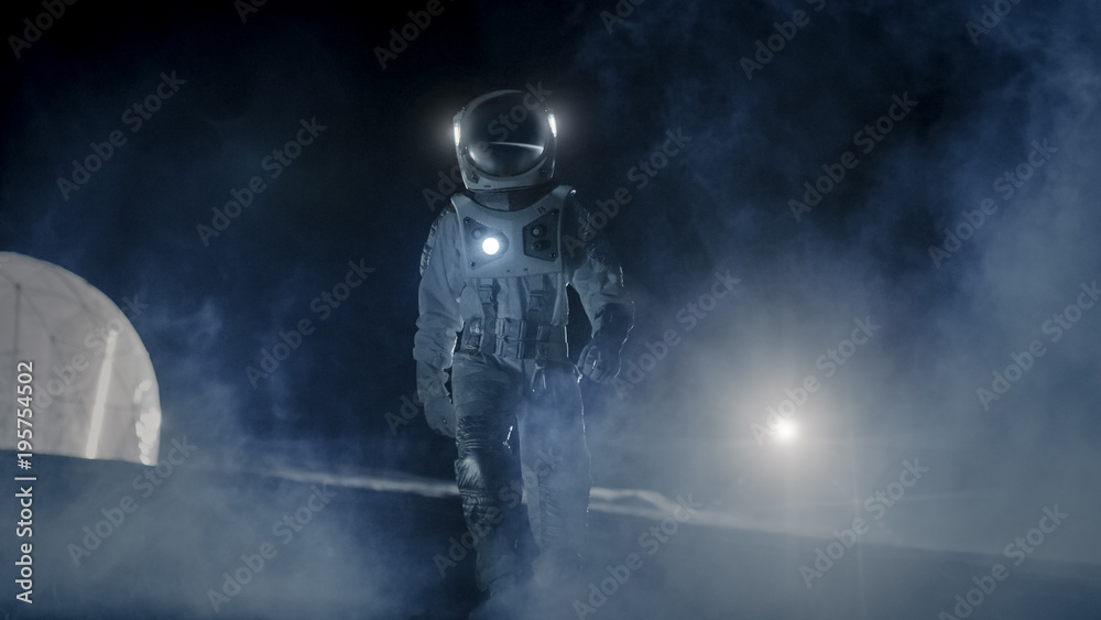 Courageous Astronaut in the Space Suit with Flashlight Explores Mysterious Alien Planet Covered in M