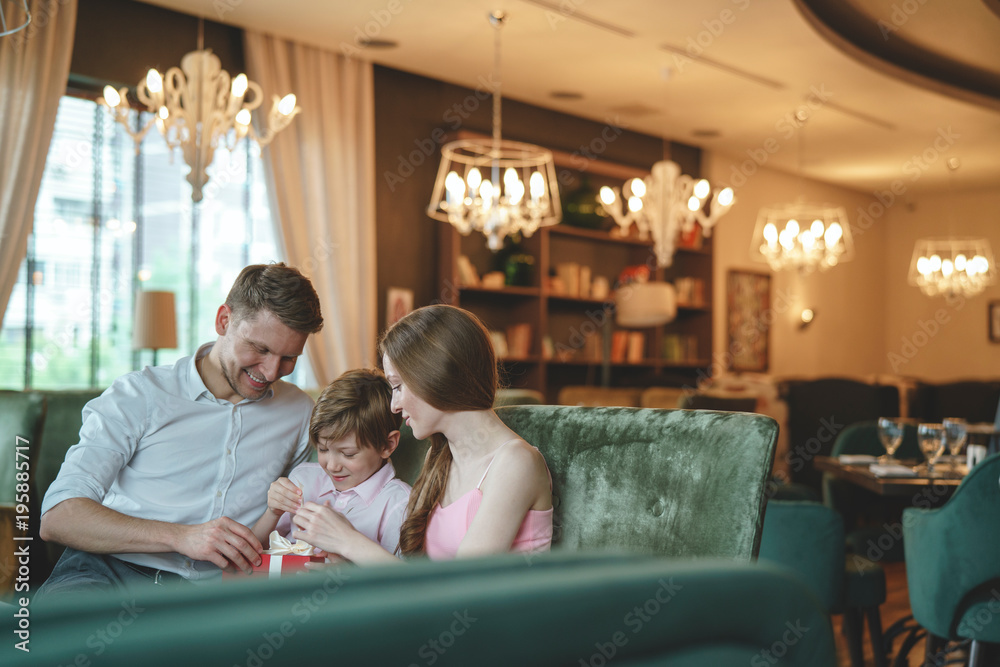 Young family with a gift indoors