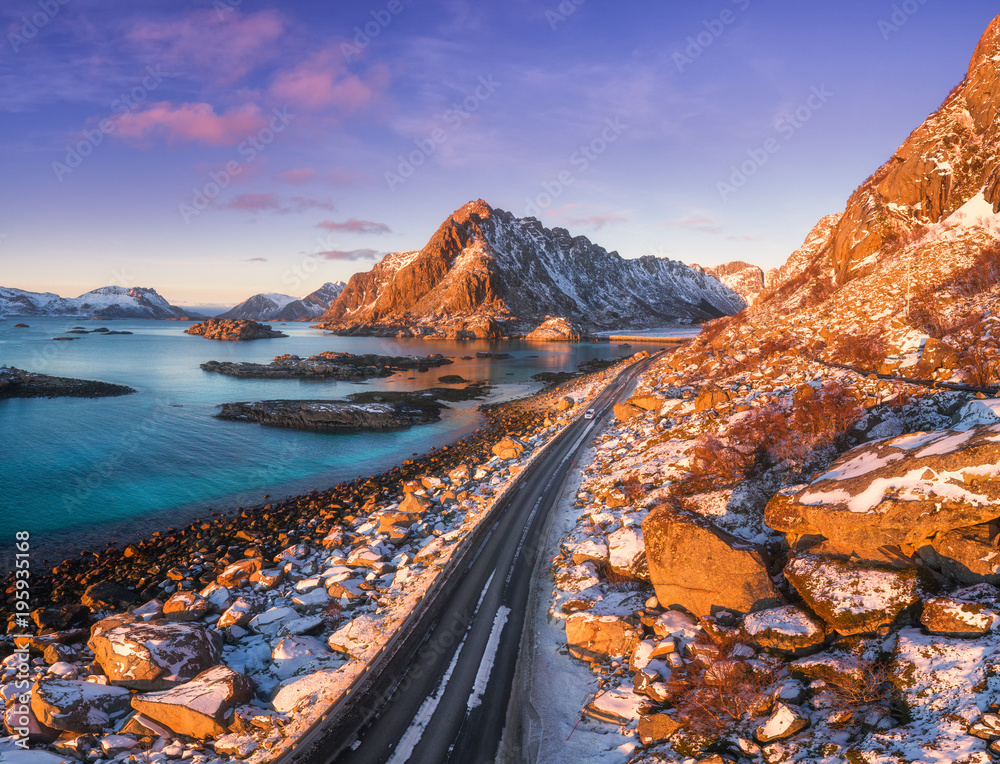 Aerial view of beautiful mountain road near the sea, mountains, purple sky at sunset in Lofoten isla