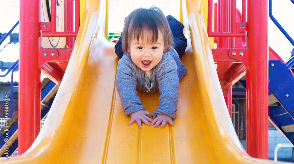 混血幼童在操场上玩滑梯