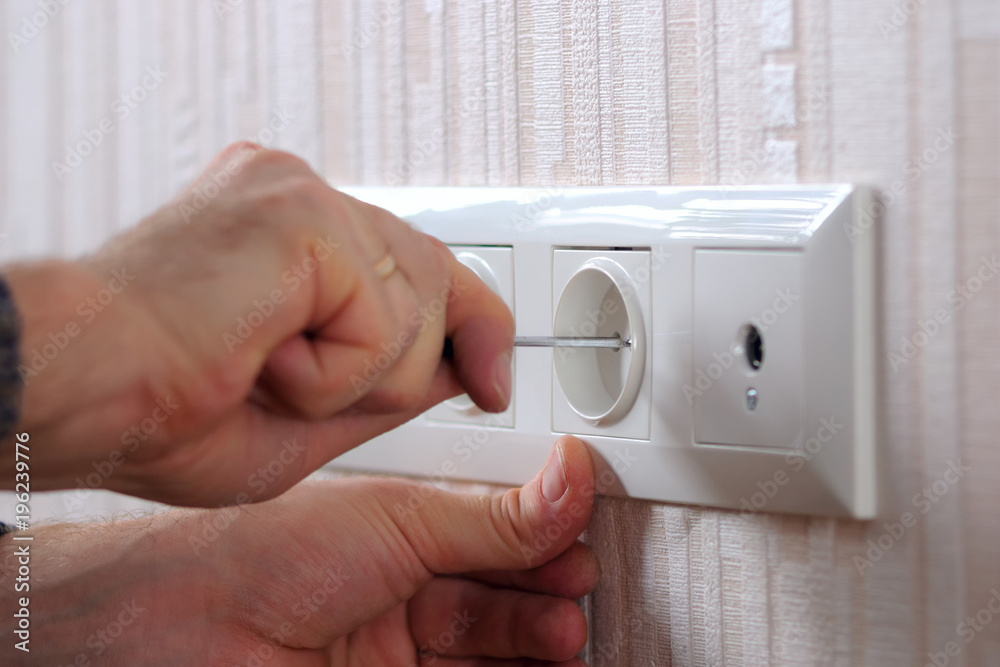 Wall power sockets installation. Man with screwdriver installing group of electrical outlets and TV 