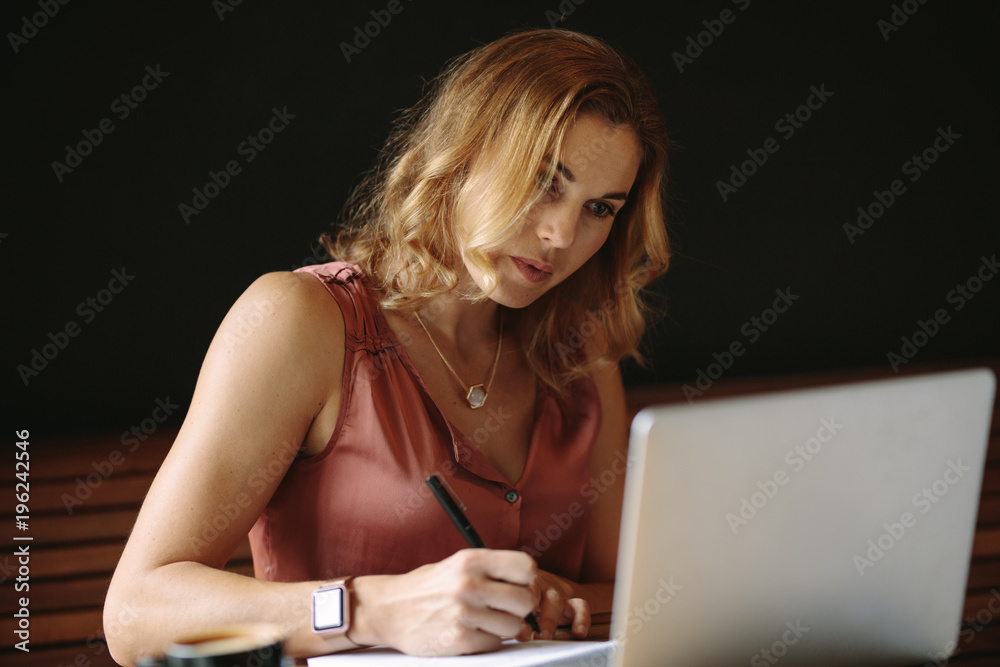 Woman working on a laptop computer at a coffee shop