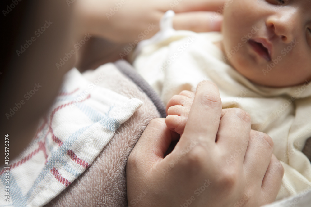 子供の手を優しく握る母親