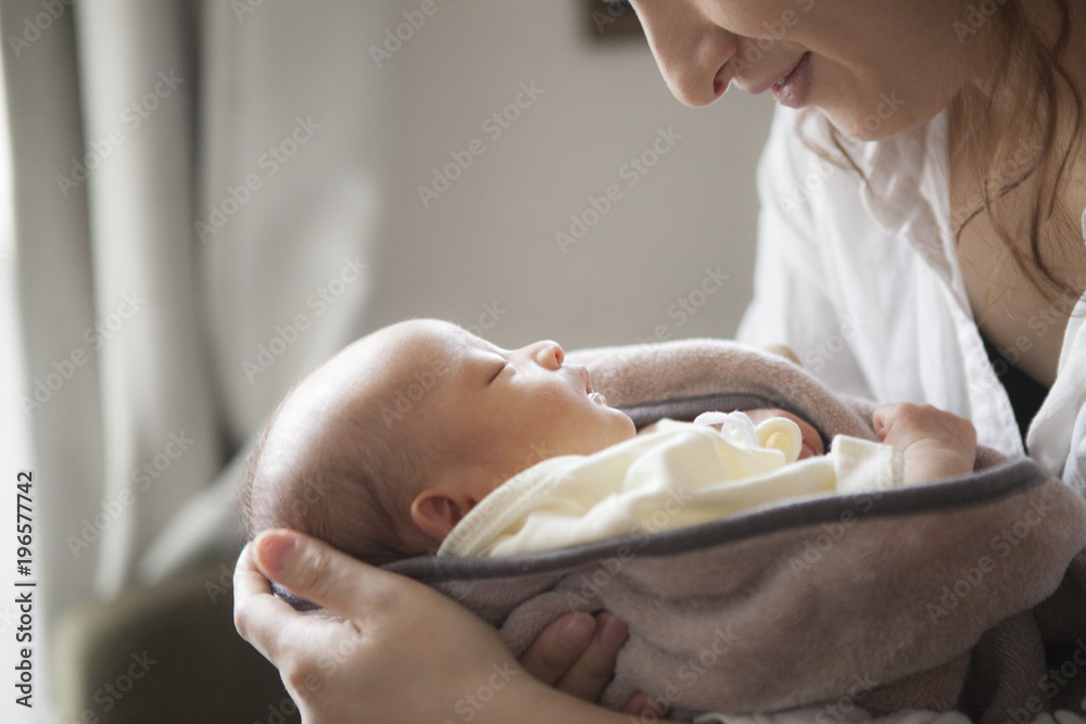 眠っている子供を抱きかかえる母親