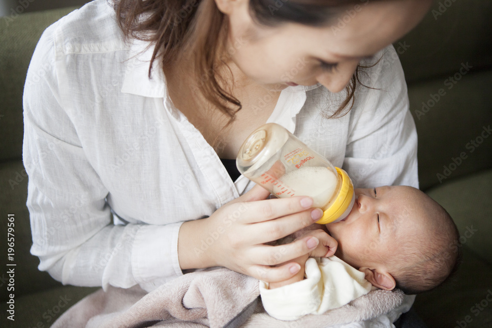 母親が子供に哺乳瓶で授乳している