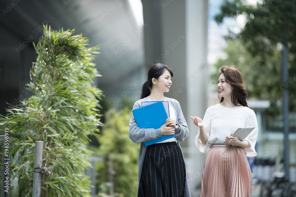 会話をしながらオフィス街を歩く女性社員達