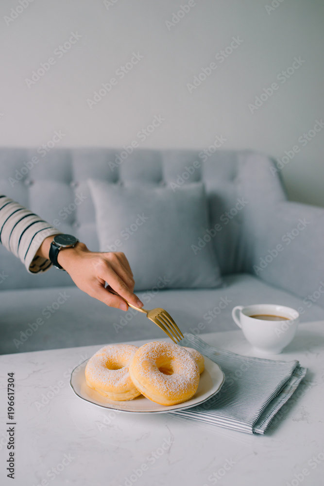 Food and Bakery, Hand Holding Delicious Fresh and Sweet Donut with Sugar Toppings on White Dish.