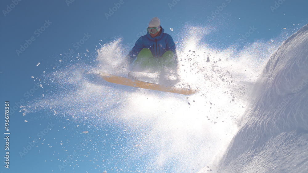 特写：有灯光的骑手在空中跳跃后表演了一个很酷的滑雪技巧。