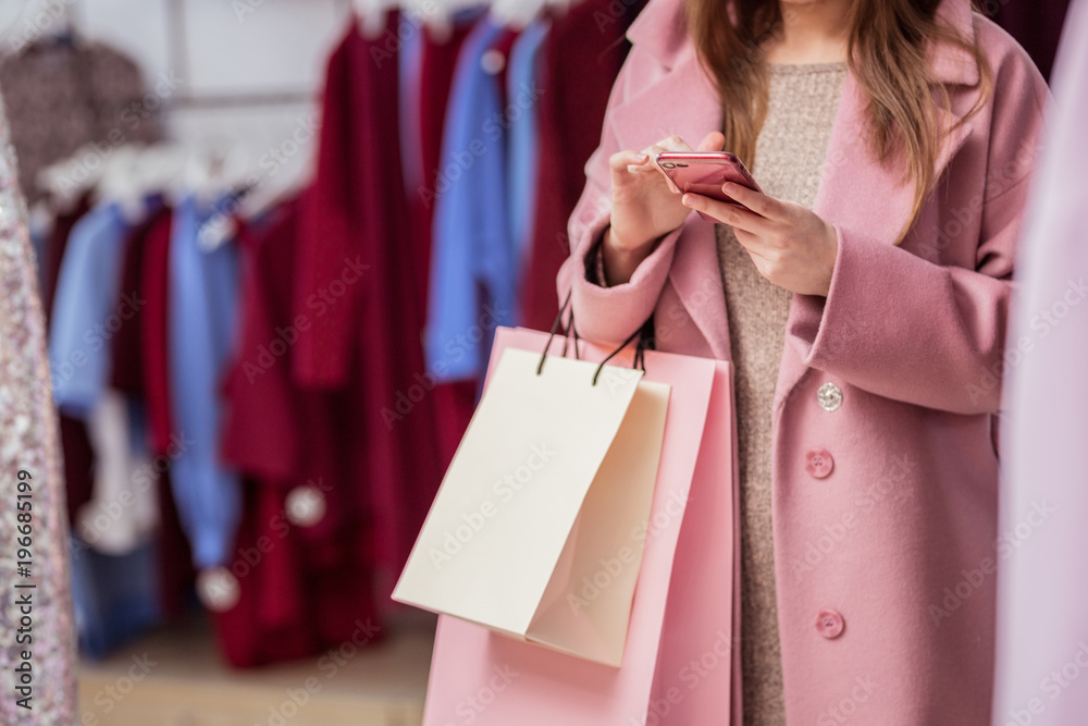 Young girl with shopping bags indoors