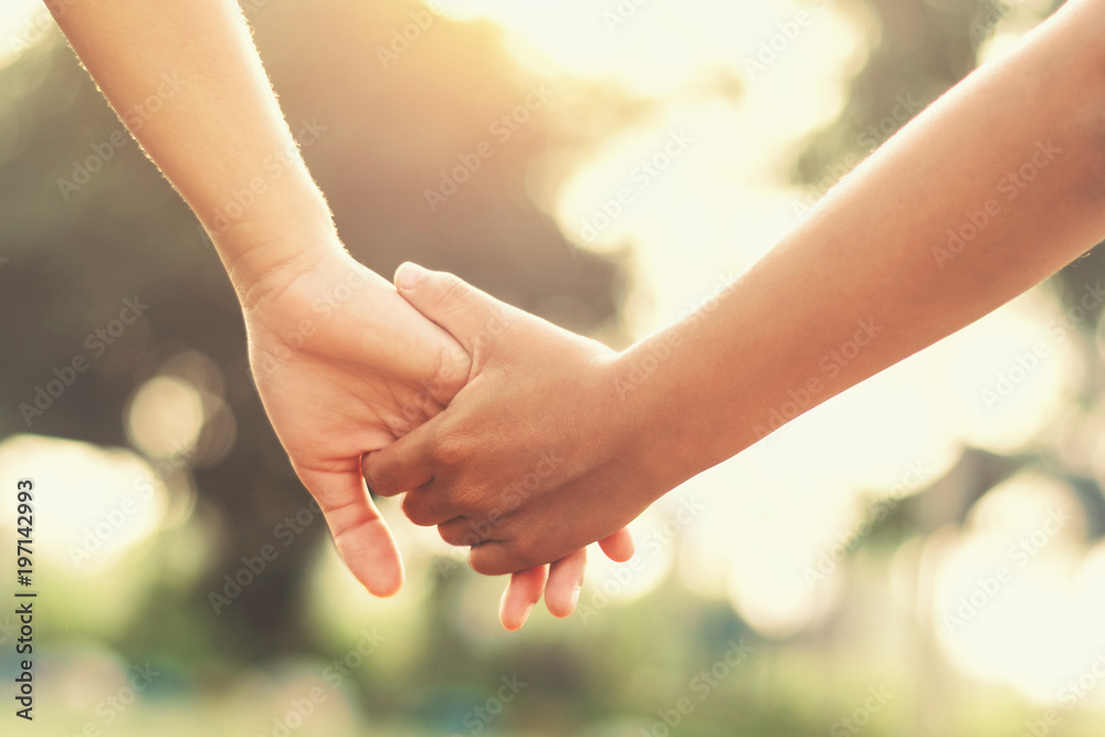 close up hand couple holding walking in park with sunset