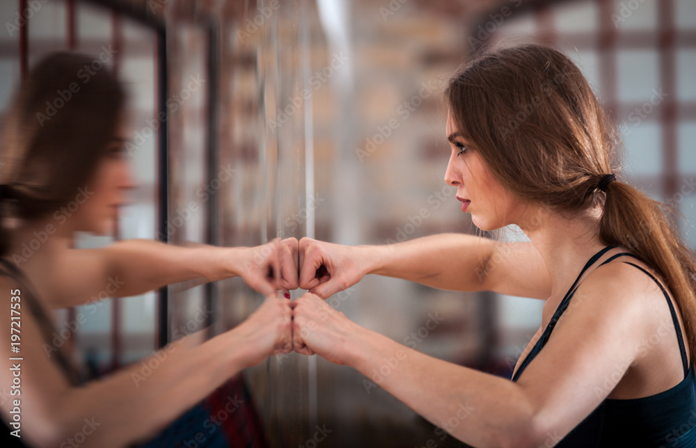 Woman motivation during training at fitness gym in front of the mirror looking at herself