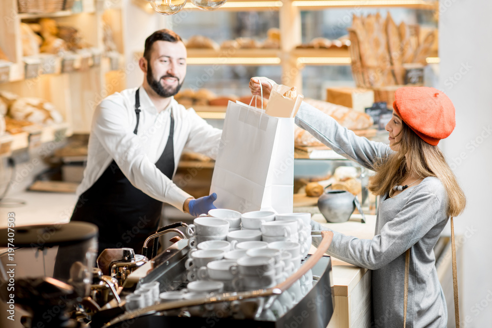 Woman buying some bakery products in the small and cozy coffee house