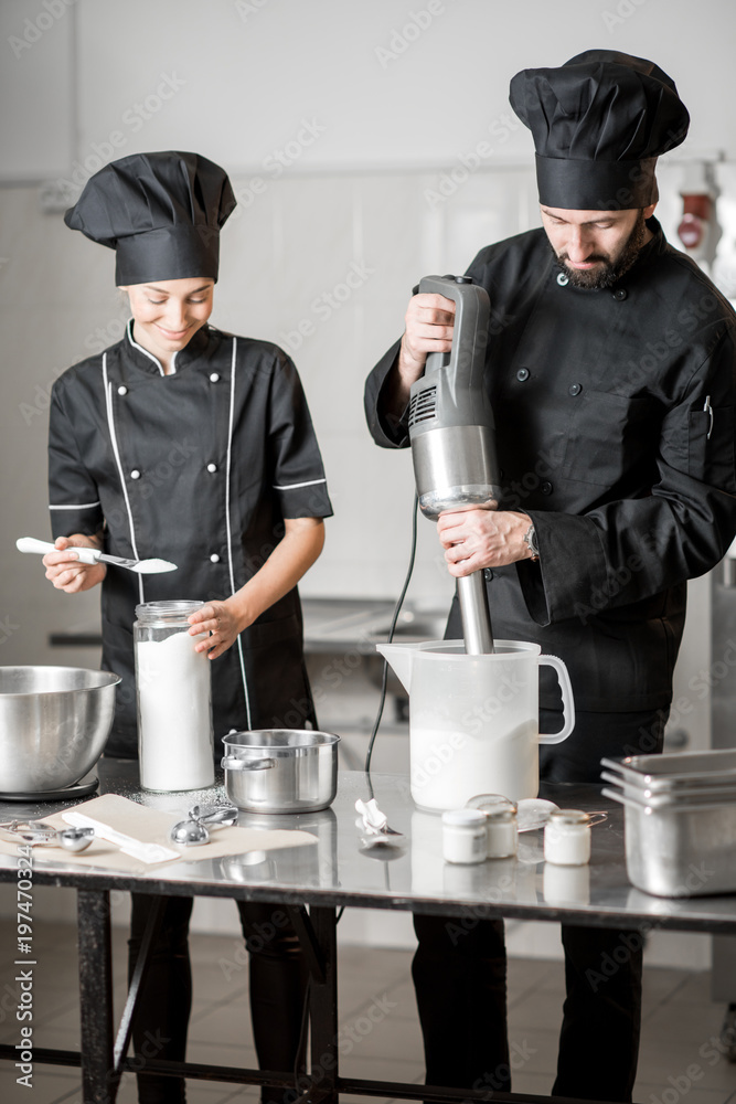 厨师与年轻女性助理一起制作冰淇淋，在专业餐厅混合食材