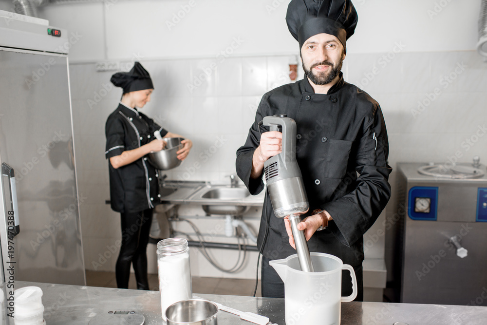 厨师与年轻女性助理一起制作冰淇淋，在专业餐厅混合食材