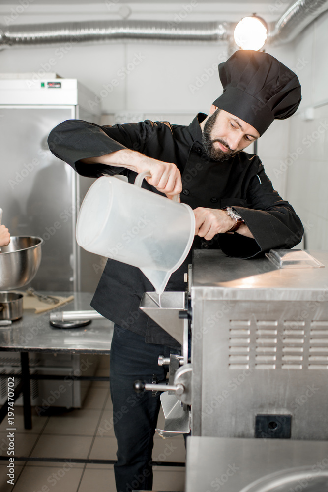 Chef pouring basis into the ice cream freezer machine in the small manufacturing