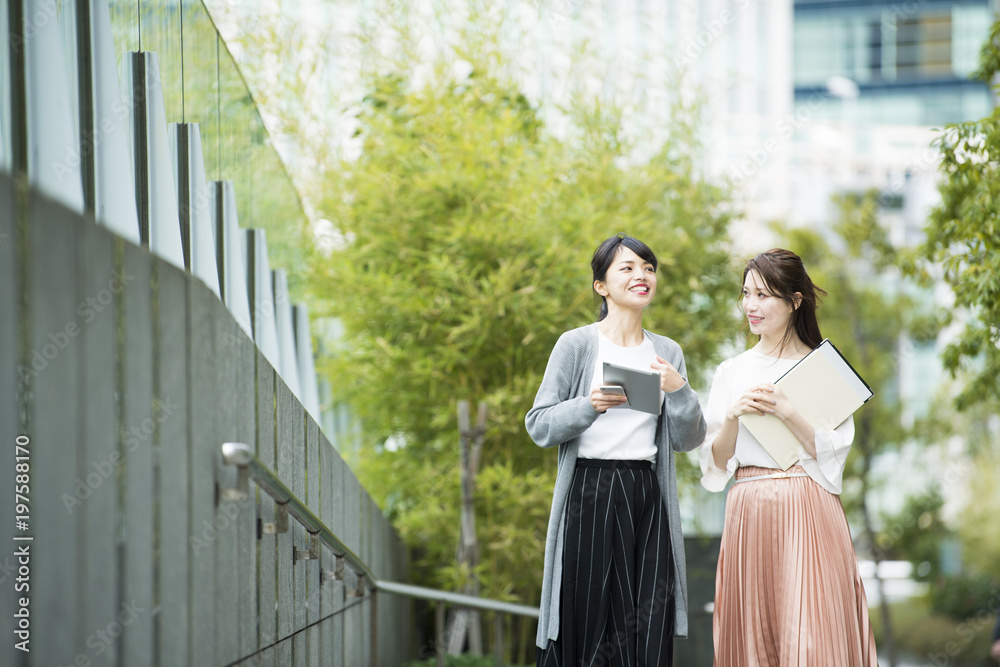 女性社員たちがオフィス街を歩いている