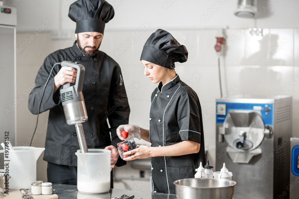 Chefs mixing berries with milk and sugar for ice cream production in the small ice cream manufacturi