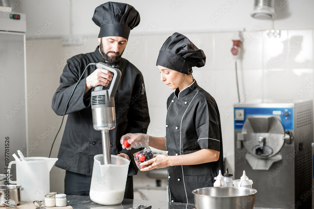 Chefs mixing berries with milk and sugar for ice cream production in the small ice cream manufacturi