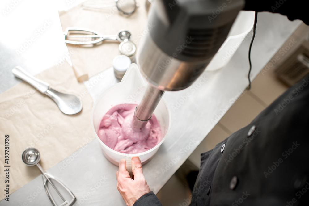 Mixing milk with sugar and berries for ice cream production