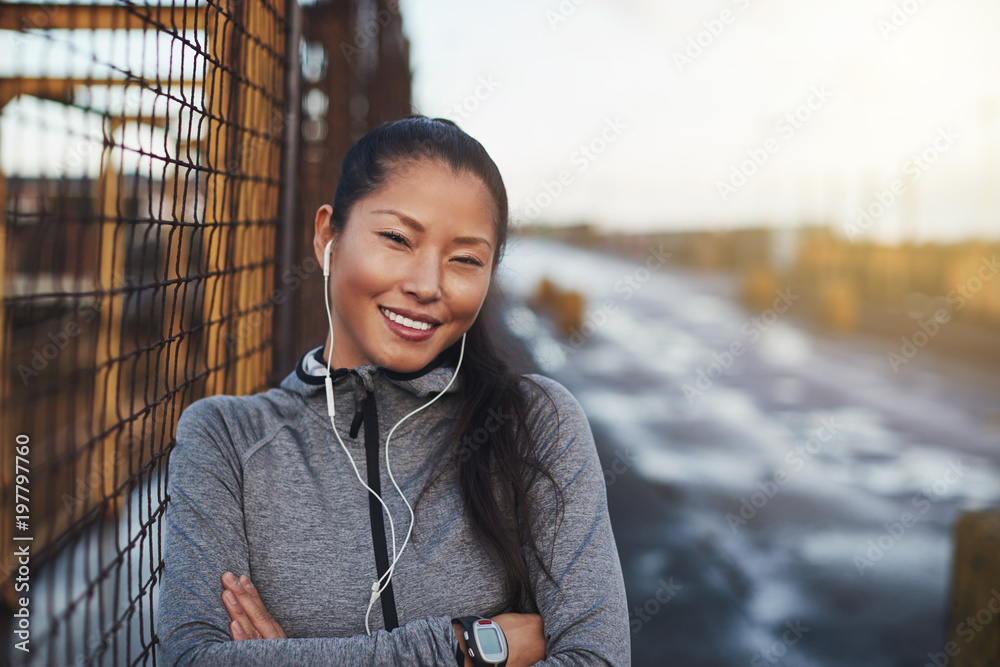 穿着运动服的亚洲女性跑步前听音乐