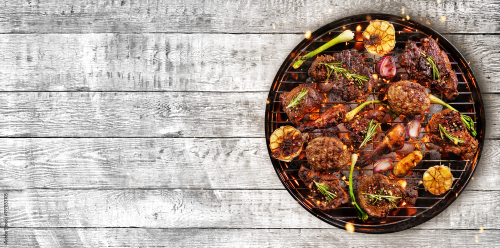 Top view of fresh meat and vegetable on grill placed on wood