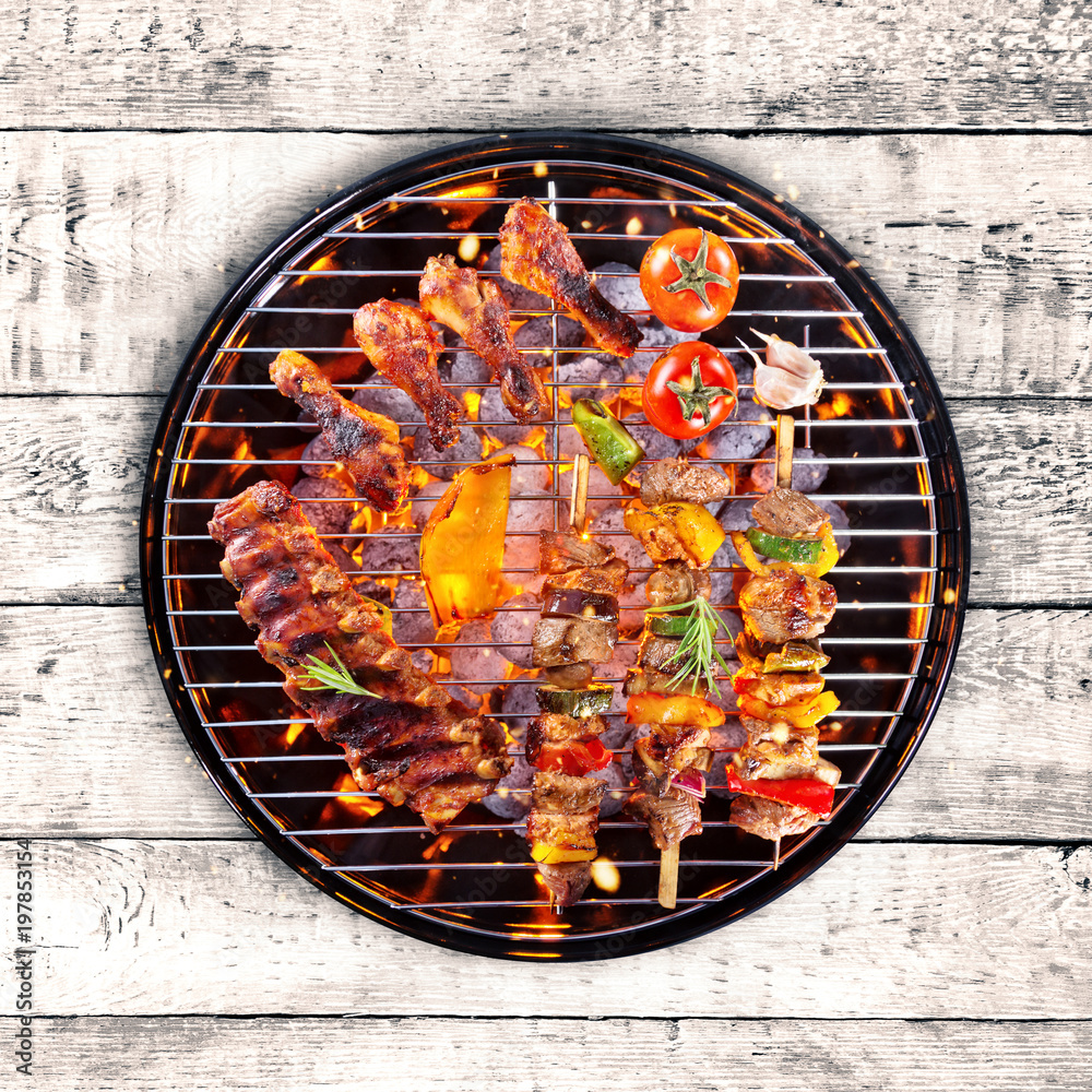 Top view of fresh meat and vegetable on grill placed on wood