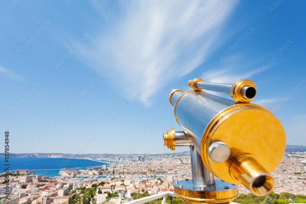 Brass telescope overlooking cityscape of Marseille