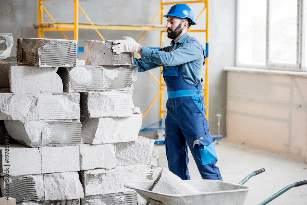 穿着制服的建筑工人在室内施工现场使用积木