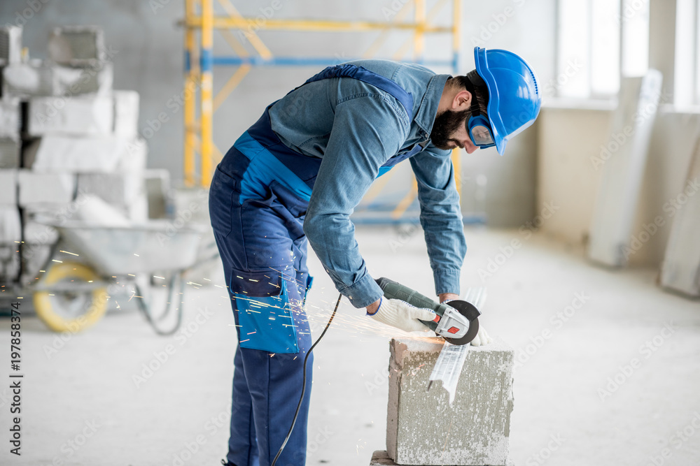 在印度建筑工地用切割机加工均匀切割金属型材的建设者