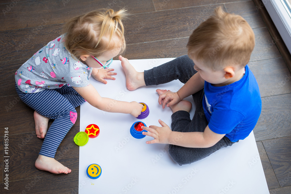 Brother and sister twins learn how to paint by hands