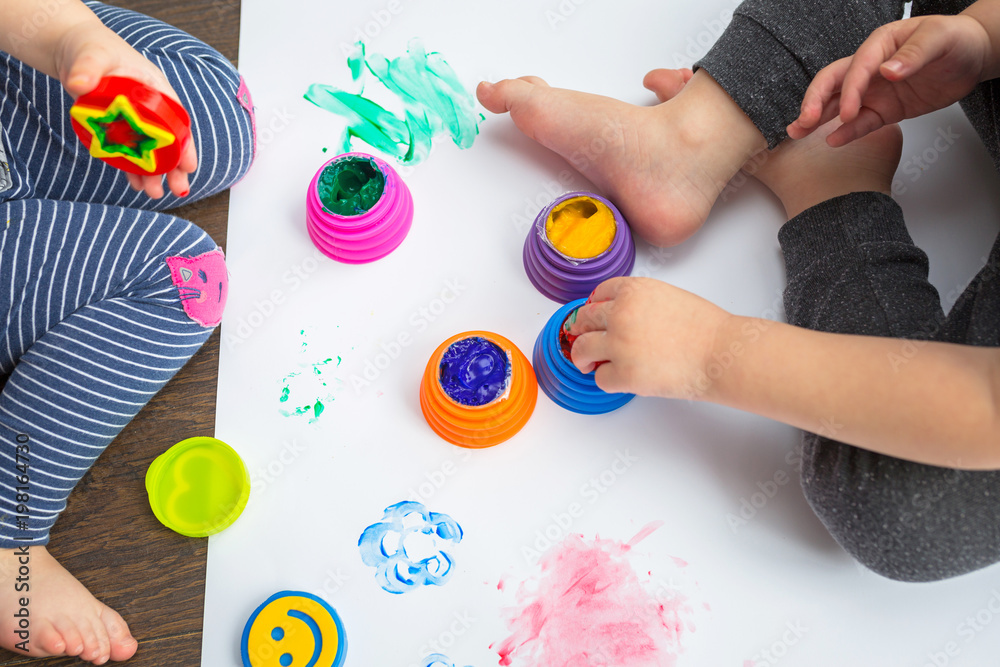 Brother and sister twins learn how to paint by hands