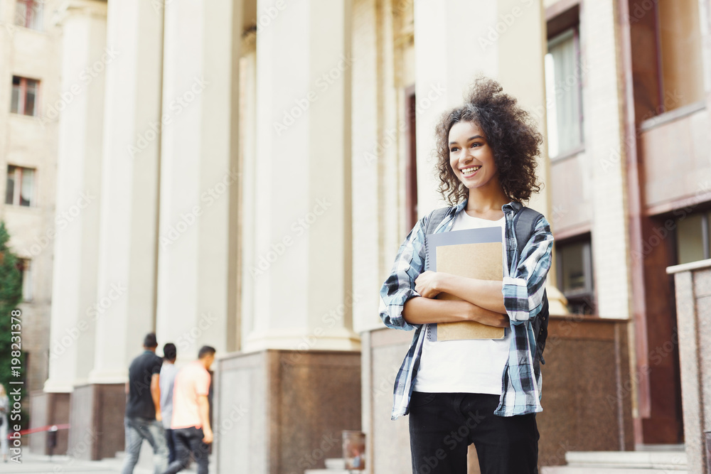 大学里拿着书的非裔美国学生