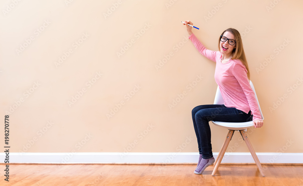 Young woman drawing something on a big open wall