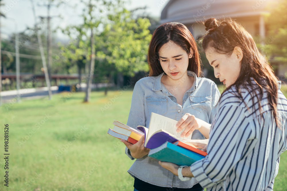 一群十几岁的大学生在暑假里微笑着看书。