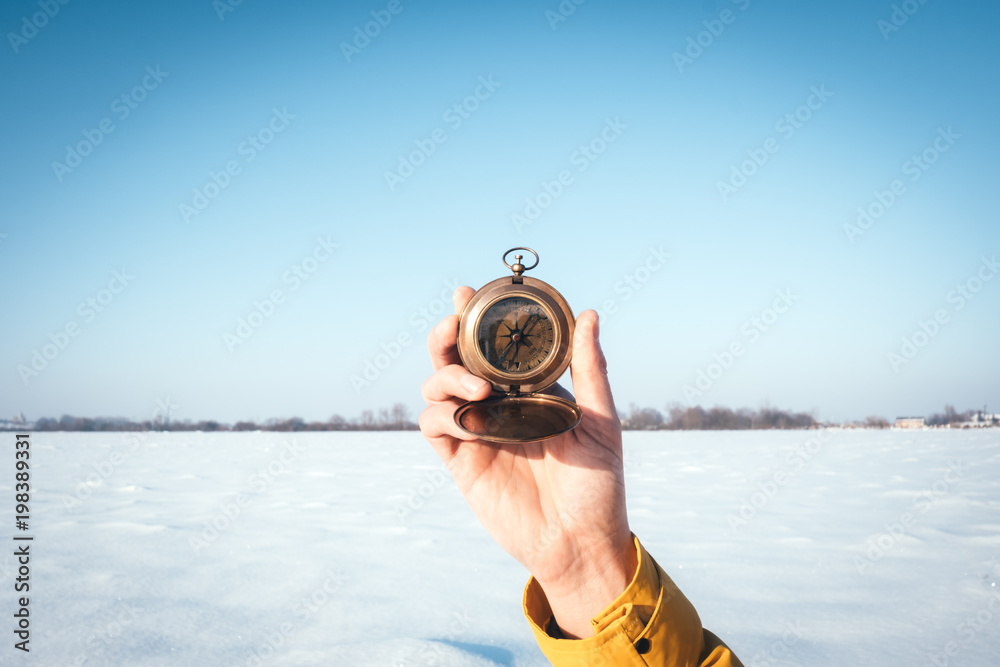 冬天雪地上拿着指南针的人。旅行概念