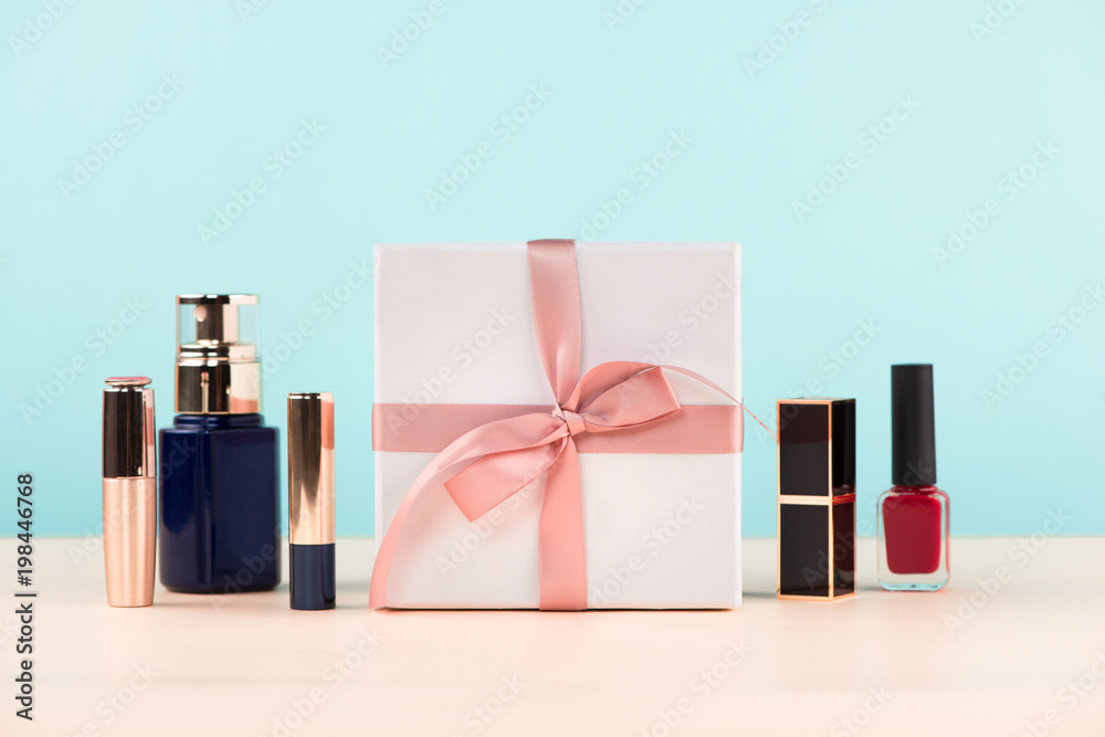 Cosmetics with a present box over blue background.