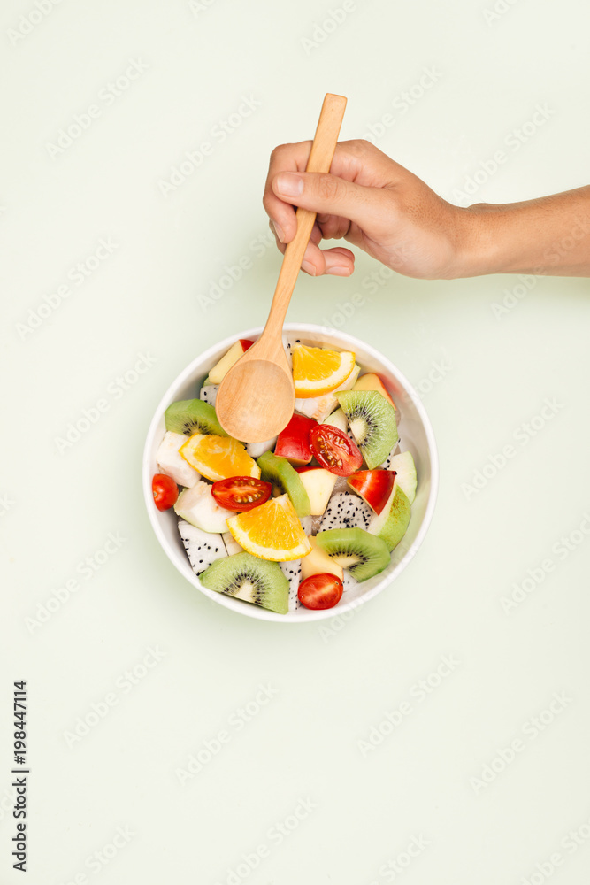 Bowl of healthy fresh fruit salad on white background. Top view.