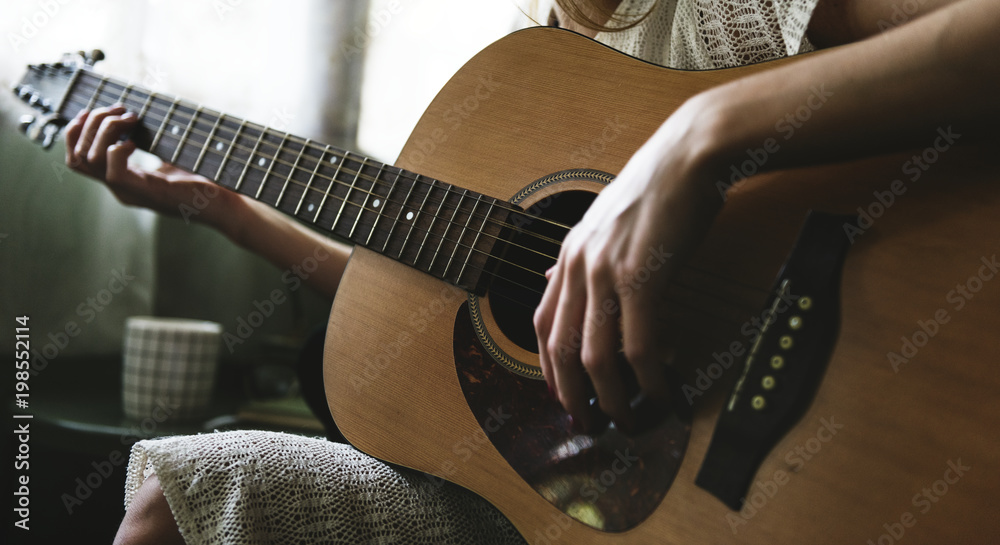 Caucasian woman relaxing and playing guitar