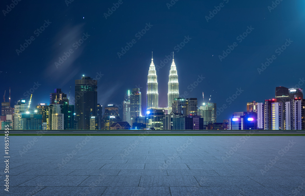 空荡荡的广场一楼，背景是城市天际线。夜景。