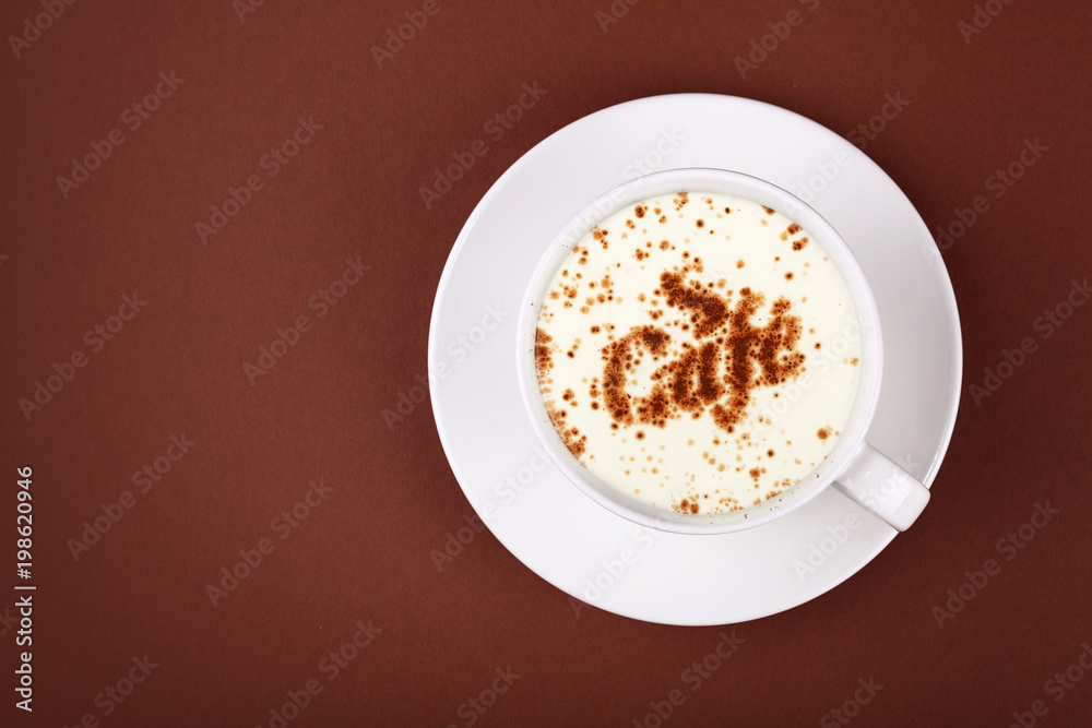 Full white cup of cappuccino coffee on brown