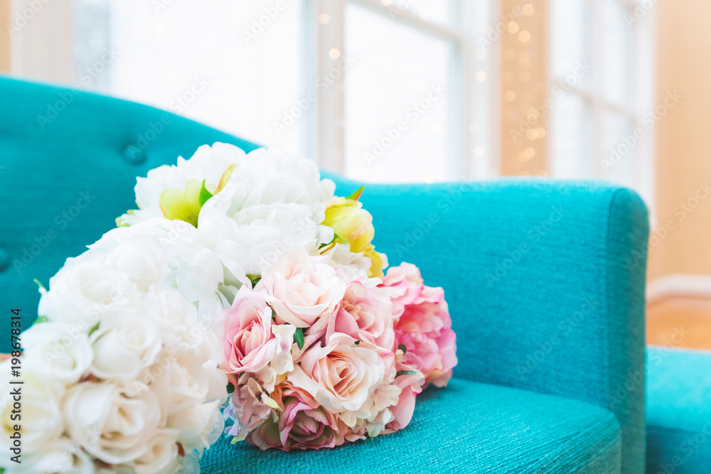 Flower bouquets in large luxury interior home with turquoise chair