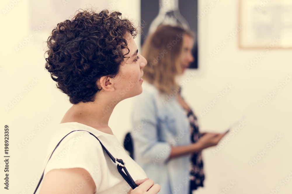 People looking at frames in an exhibition