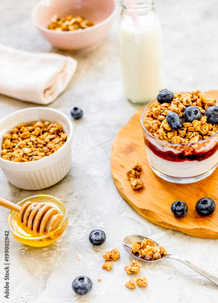 Morning granola with yogurt, honey and berries on white table