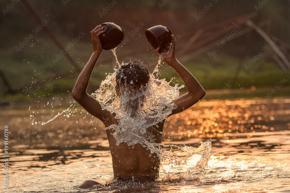 Rural chaidren playing water in the river.