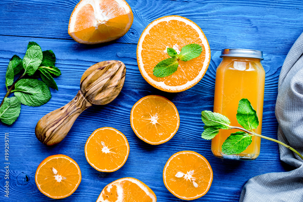 Orange juice in bottle with slices and mint on table top view