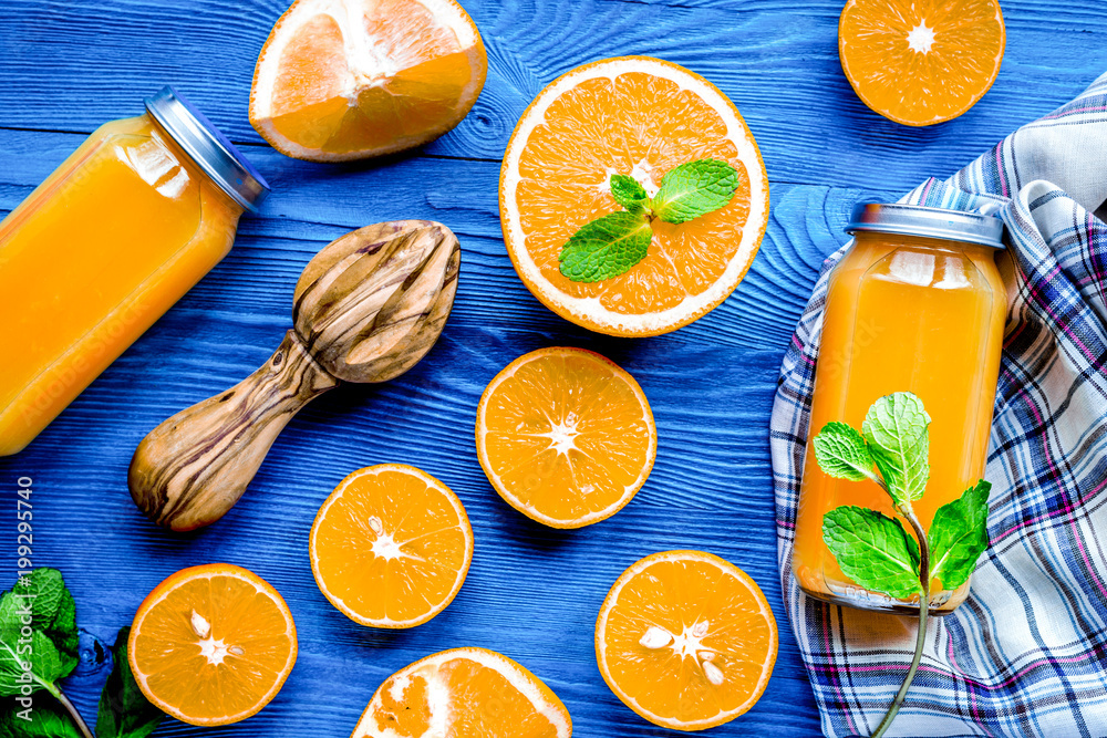 Homemade juice bottles with orange and mint on table top view