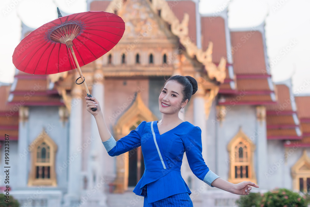 美丽的泰国女孩，穿着泰国服装，带着雨伞。