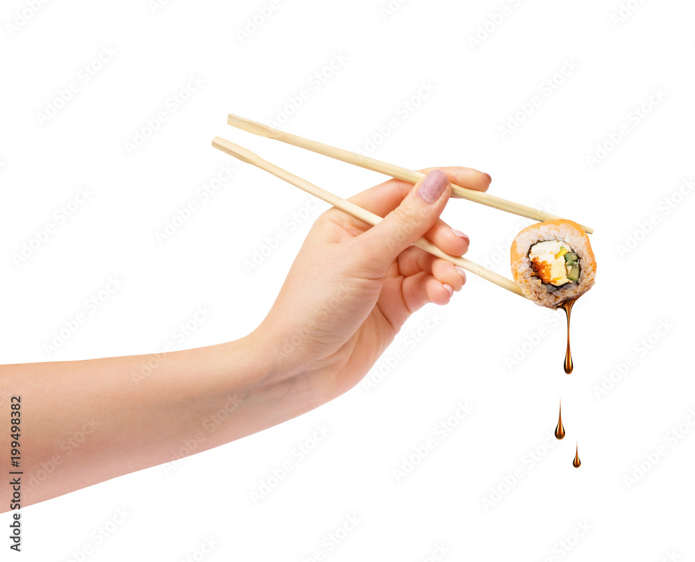 Sushi roll with wooden chopsticks in female hand on white background