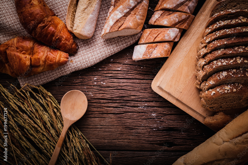 Fresh baked bread on dark wood table with copy space background  still life composition with wheat f