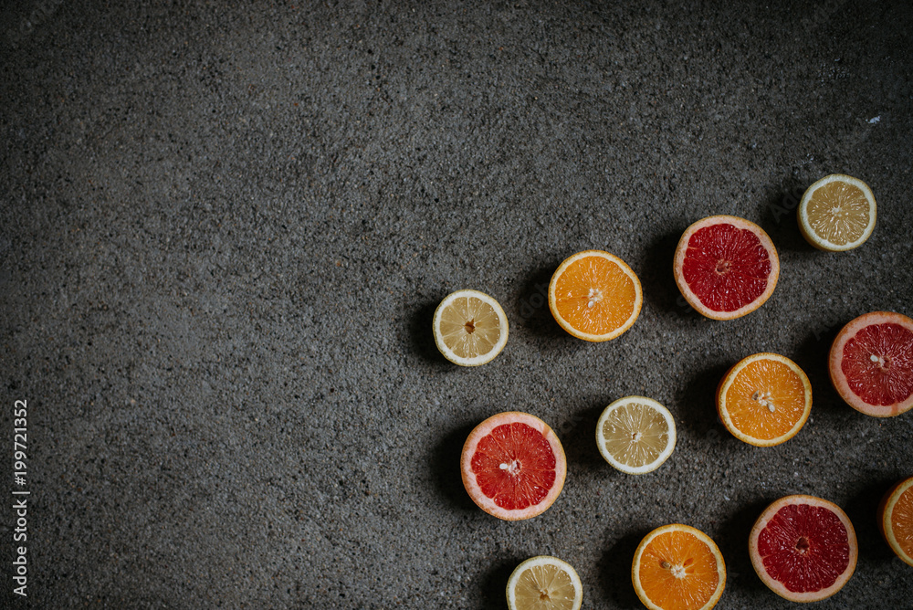 Food background. Slices of variety citrus on concrete background.